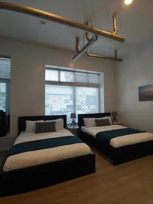 two beds in a room with two windows at AIR Venice on the Beach in Los Angeles