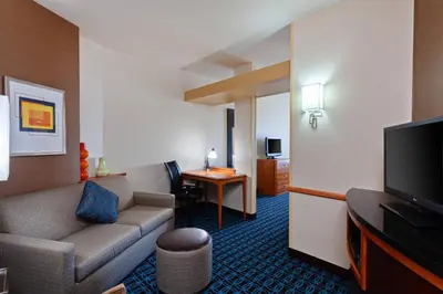 a hotel room with a couch and a television at Fairfield Inn & Suites - Los Angeles West Covina in West Covina