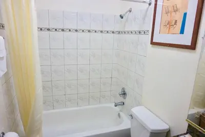 a bathroom with a white tub and a toilet at Satellite Motel, Los Angeles - LAX in South Los Angeles
