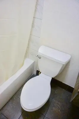 a bathroom with a white toilet and a bath tub at Satellite Motel, Los Angeles - LAX in South Los Angeles