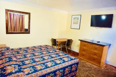 a bedroom with a bed and a dresser and a desk at Satellite Motel, Los Angeles - LAX in South Los Angeles