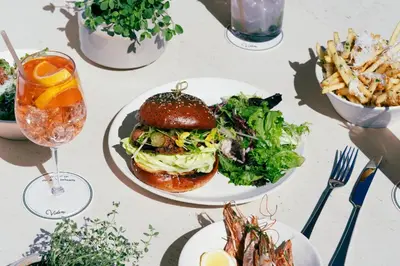 a table with plates of food and a sandwich and salad at Kimpton Hotel Wilshire by IHG in Los Angeles
