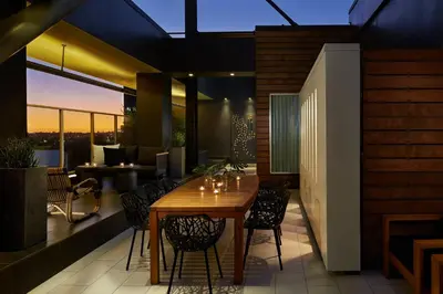 a dining table and chairs on a patio with a view at Kimpton Hotel Wilshire by IHG in Los Angeles