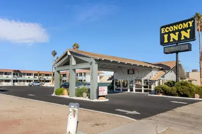 a gas station with a sign in a parking lot at Economy Inn Barstow in Barstow