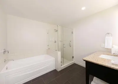 a white bathroom with a tub and a shower at Jamaica Bay Inn Marina Del Rey Tapestry Collection by Hilton in Los Angeles