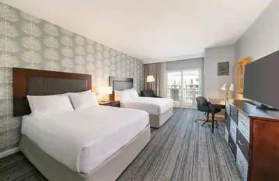 a hotel room with two beds and a desk and a television at Jamaica Bay Inn Marina Del Rey Tapestry Collection by Hilton in Los Angeles