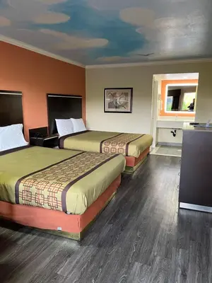 a hotel room with two beds and a window at Rivera Inn & Suites Motel in Pico Rivera