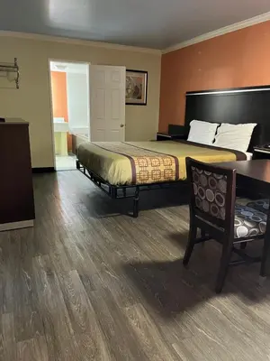 a hotel room with a bed and a desk at Rivera Inn & Suites Motel in Pico Rivera