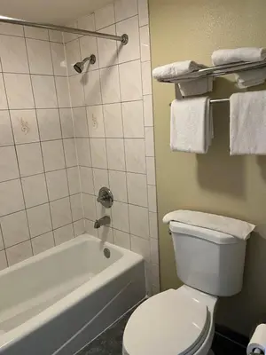 a bathroom with a white toilet and a bath tub at Rivera Inn & Suites Motel in Pico Rivera
