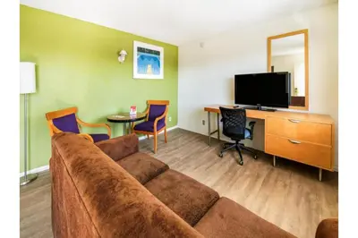 a living room with a couch and a table with chairs at Hotel Ridgecrest An Extended Stay Studio in Ridgecrest