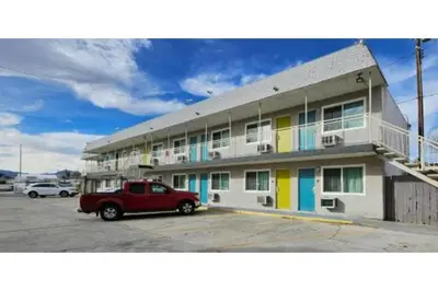 a red truck parked in front of a building at Hotel Ridgecrest An Extended Stay Studio in Ridgecrest