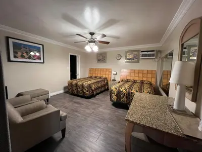 a hotel room with two beds and a couch at Flamingo Motel Oxnard in Oxnard