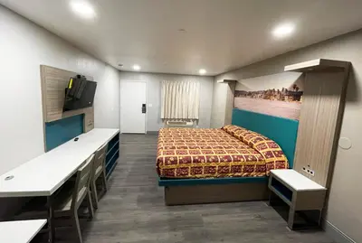 a bedroom with a bed and a desk and a tv at New Star Inn El Monte, CA - Los Angeles in El Monte