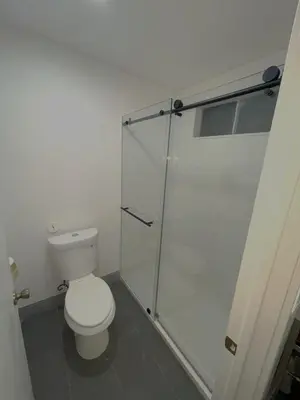 a bathroom with a toilet and a glass shower at New Star Inn El Monte, CA - Los Angeles in El Monte