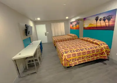 a hotel room with two beds and a table at New Star Inn El Monte, CA - Los Angeles in El Monte