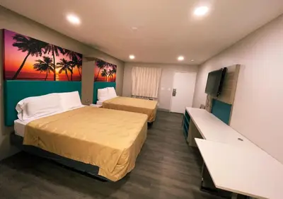 a hotel room with two beds and a flat screen tv at New Star Inn El Monte, CA - Los Angeles in El Monte