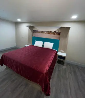 a bedroom with a large bed with a red bedspread at New Star Inn El Monte, CA - Los Angeles in El Monte