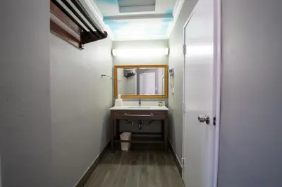 a bathroom with a sink and a mirror at Hollywood Palms Inns & Suites in Los Angeles