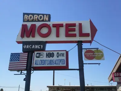 a sign for a motel with an american flag at Boron Motel in Boron