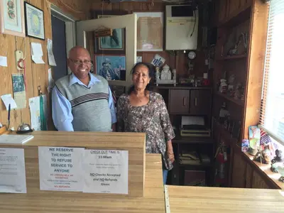 a man and a woman standing behind a counter at Boron Motel in Boron