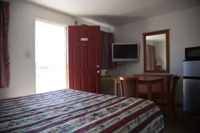 a bedroom with a bed and a desk and a television at Boron Motel in Boron