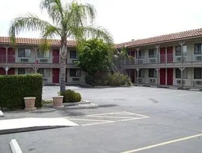 an empty parking lot in front of a large building at Regency Inn in Norco
