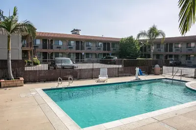 a swimming pool with a chair next to a building at Regency Inn in Norco