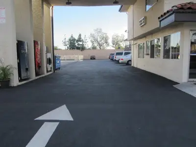 an empty parking lot with an arrow painted on it at Little Boy Blue Motel in Anaheim
