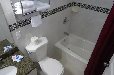 a bathroom with a toilet and a sink and a bath tub at Little Boy Blue Motel in Anaheim
