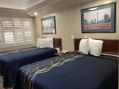 a hotel room with two beds and a phone at Little Boy Blue Motel in Anaheim