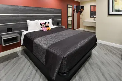 a bedroom with a large bed with two stuffed animals on it at Pacific Inn Anaheim in Anaheim