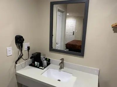 a bathroom with a sink and a mirror at Pacific Inn Anaheim in Anaheim