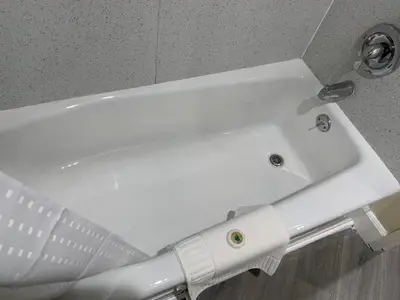 a white sink in a bathroom next to a wall at Pacific Inn Anaheim in Anaheim