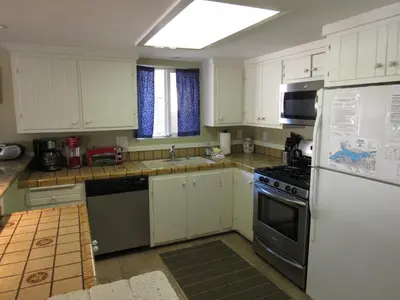 a kitchen with white cabinets and a stove top oven at Big B's Den in Big Bear Lake