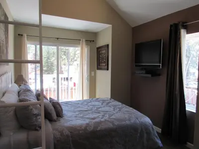 a bedroom with a bed and a tv and a window at Big B's Den in Big Bear Lake