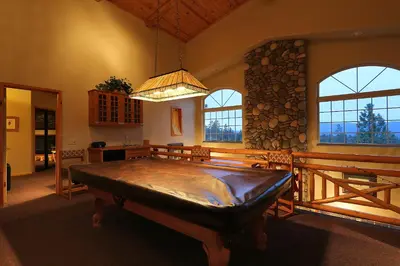 a large room with a large wooden table in front of windows at Summit Ski-Inn Ski-Out in Big Bear Lake