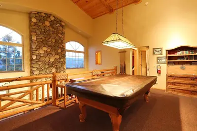 a dining room with a table and a stack of logs at Summit Ski-Inn Ski-Out in Big Bear Lake