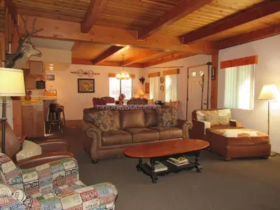 a living room with couches and a table and chairs at Miller's Outpost in Big Bear Lake