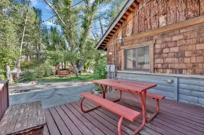 a red picnic table and a bench on a deck at Lodge House-Family Cabin with Pool Table by Big Bear Vacations in Big Bear Lake