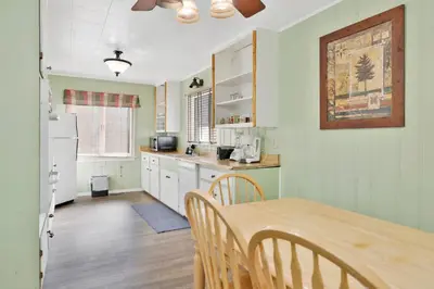 a kitchen with a table and chairs and a refrigerator at Lodge House-Family Cabin with Pool Table by Big Bear Vacations in Big Bear Lake