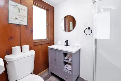 a bathroom with a toilet and a sink and a mirror at Big Pines Couple Lakeview Studio Cabin by Big Bear Vacations in Big Bear Lake