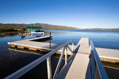 a dock on a lake with a boat in the water at Lakeview Family Cabin by Big Bear Vacations in Big Bear Lake
