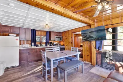 a kitchen with wooden cabinets and a table and chairs at Lakeview Family Cabin by Big Bear Vacations in Big Bear Lake