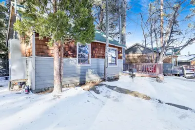 a house with snow on the ground at Lupine Lakeside Resort Cabin by Big Bear Vacations in Big Bear Lake