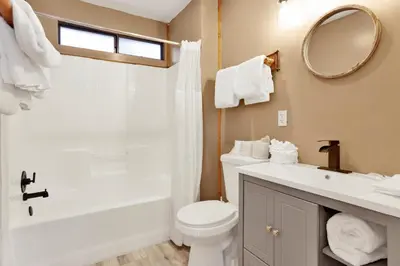 a bathroom with a toilet and a sink and a mirror at Lonepine Lakeside Resort Retreat by Big Bear Vacations in Big Bear Lake