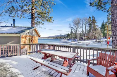a picnic table and chairs on a deck with a view of a lake at Lonepine Lakeside Resort Retreat by Big Bear Vacations in Big Bear Lake