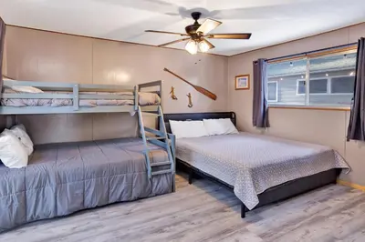 a bedroom with two bunk beds and a ceiling fan at Lakefront Family Cabin by Big Bear Vacations in Big Bear Lake