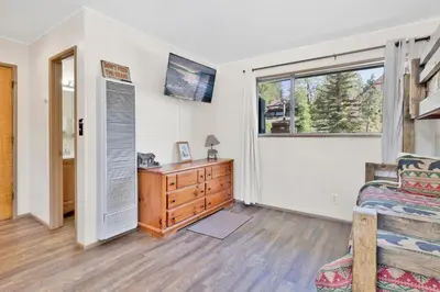 a bedroom with a bed and a dresser and a window at Twin Pines Family Cabin by Big Bear Vacations in Big Bear Lake