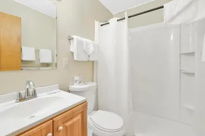 a white bathroom with a toilet and a sink at Twin Pines Family Cabin by Big Bear Vacations in Big Bear Lake