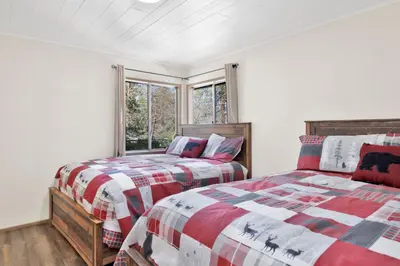 a bedroom with two beds and a window at Twin Pines Family Cabin by Big Bear Vacations in Big Bear Lake